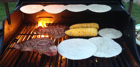 Grilling steak outdoors.